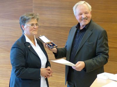 Staatssekretär Horst Schörshusen überreicht Brigitte Scherb das Bundesverdienstkreuz