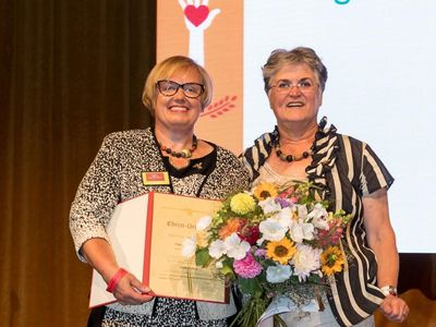 Brigitte Scherb, dlv-Präsidentin, zeichnet Ilse Wambsganß, Präsidentin des LandFrauenverbands Pfalz, auf dem Deutschen LandFrauentag 2018 mit der Goldenen Biene aus. Foto: Reiner Freese
