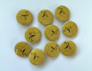 Das Bild zeigt gelbe Ansteckbuttons mit fliegender Biene.